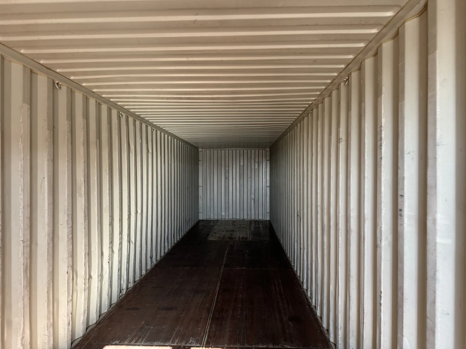 Inside an empty container: corrugated steel walls and a timber floor